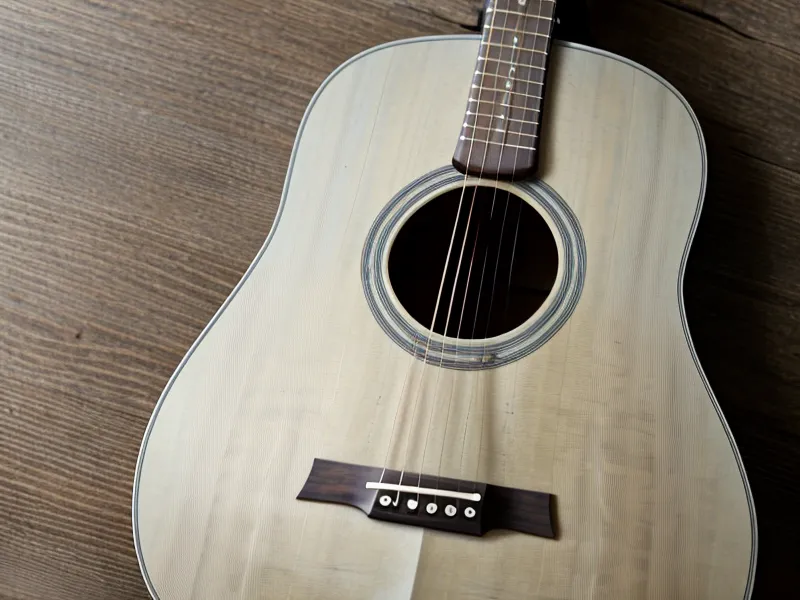 Estuche de guitarra abierto junto a apuntes después de una sesión de práctica en casa